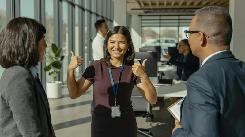 A smiling team member giving two thumbs up to her colleagues in a bright office, Notebook of a COO fractional COO services